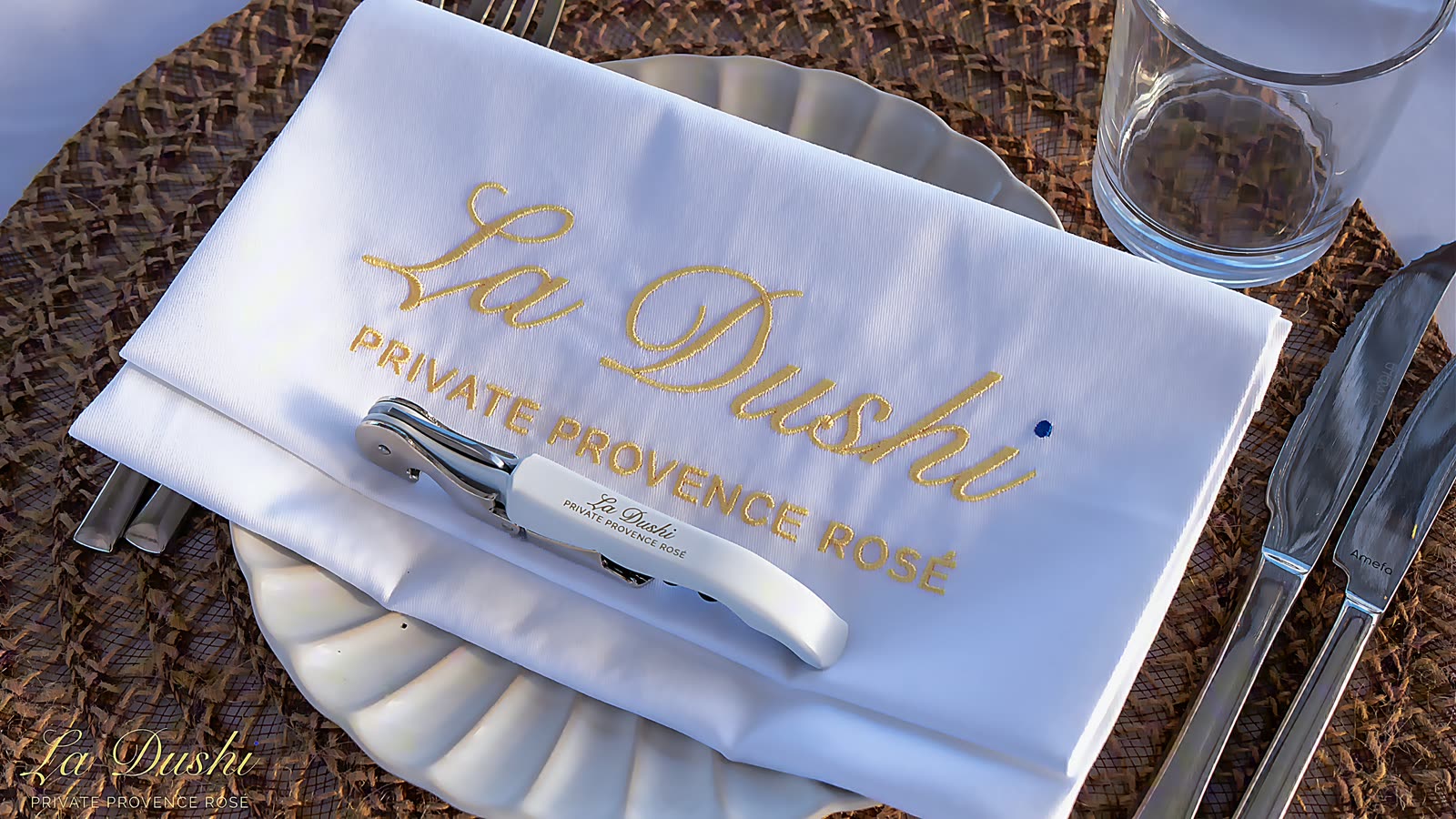 A place setting with the La Dushi wordmark embroidered on the napkin.